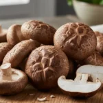 A close-up, artfully arranged display showcases the earthy textures and rich, deep brown caps of fresh shiitake mushroom.