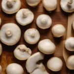 Thick white mushroom stems are sliced into rounds.