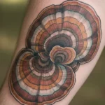 An artistic and realistic depiction of a turkey tail mushroom tattoo inked on skin.