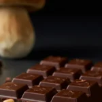 A beautifully crafted porcini mushroom chocolate bar, with visible porcini flecks, sits invitingly on a minimalist wooden table, bathed in soft, natural light, ready to be sampled.
