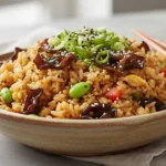 A close-up, overhead shot showcases the vibrant textures and colors of a wood ear mushroom fried rice recipe, artfully arranged in a rustic bowl with fresh garnishes.